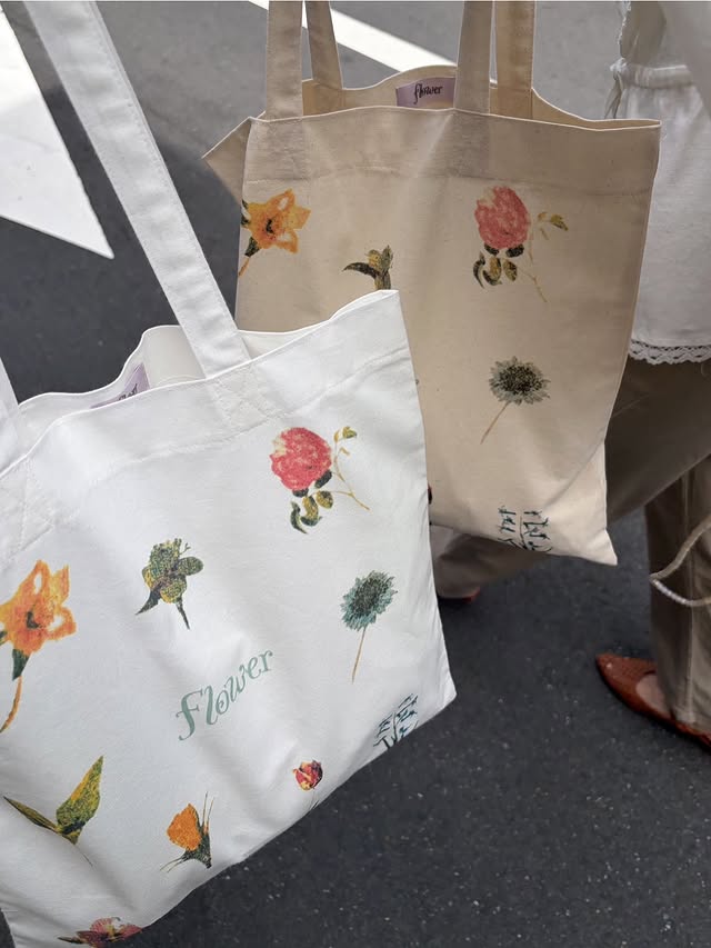 whiteとbeigeのflowerオリジナルトートバッグを並べた写真