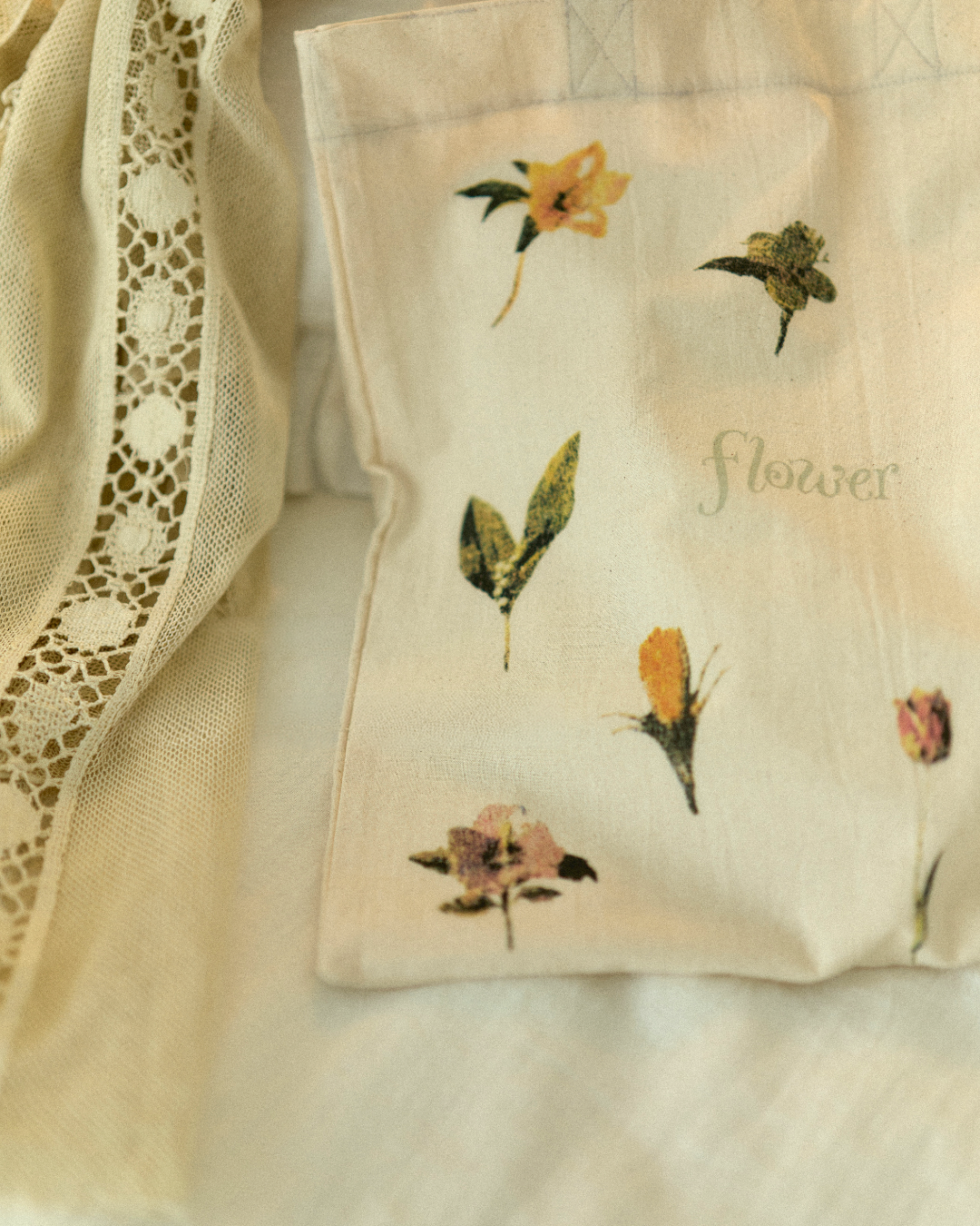 flowerのロゴと、色とりどりの花柄を写したトートバッグのアップ